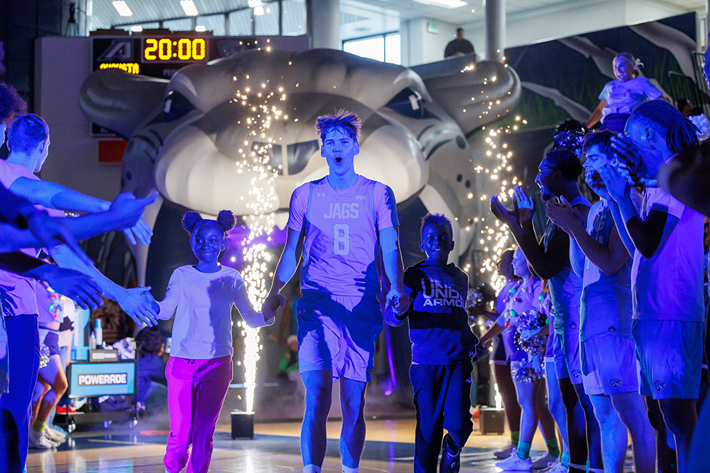 Male and female students running on to a court