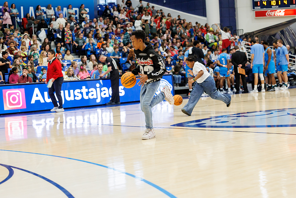 Boys and girls dribbling a basketball