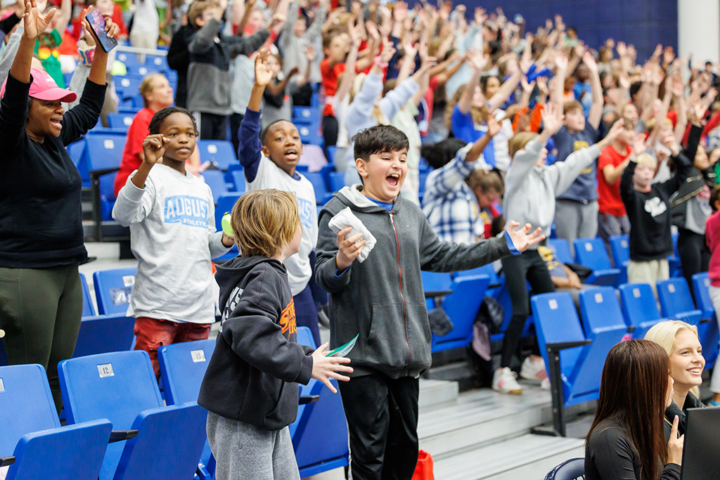 Boys and girls reacting to T-shirts being given away