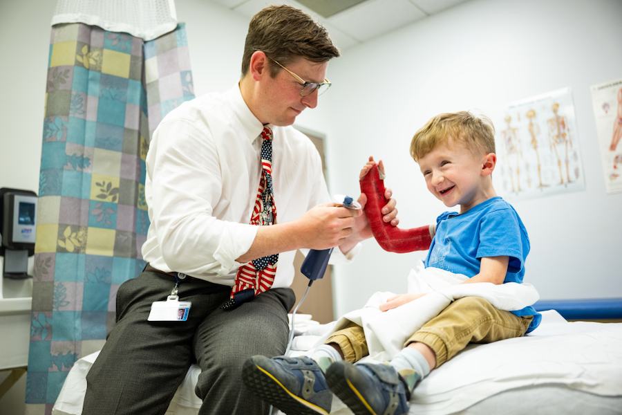 A doctor and child sit together for treatment.