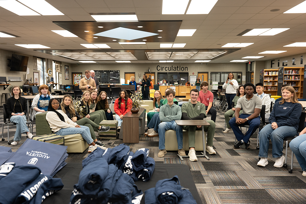 A group of high school students sit in a school library.