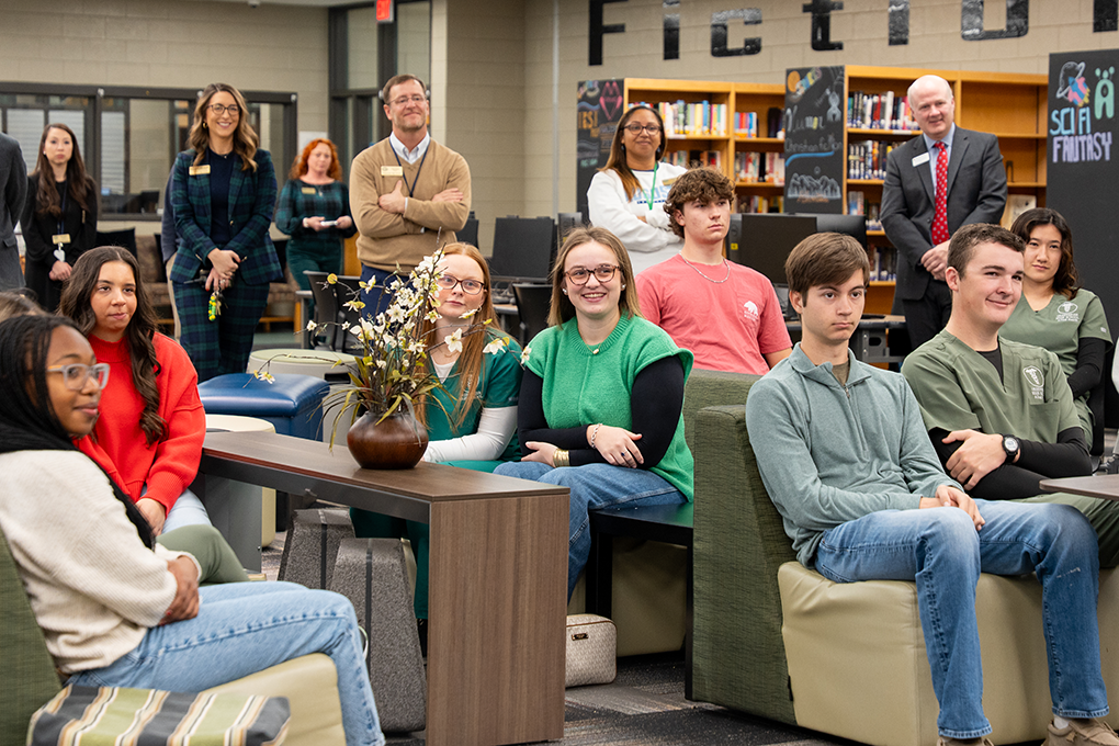 A group of high school students sit in a school library.