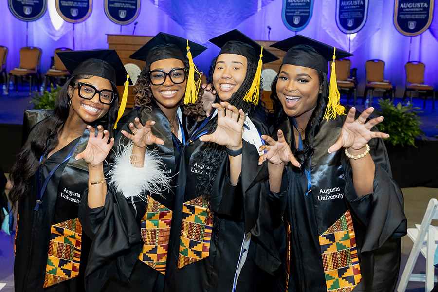 four female students in graduation caps and gowns 