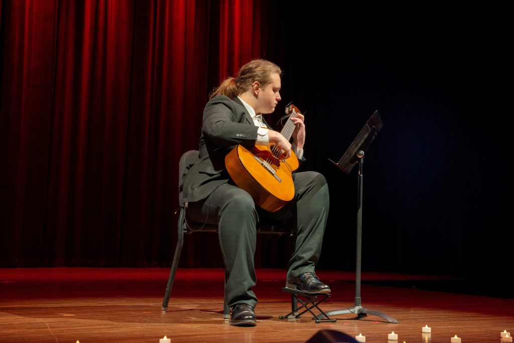 A man on stage plays a guitar.