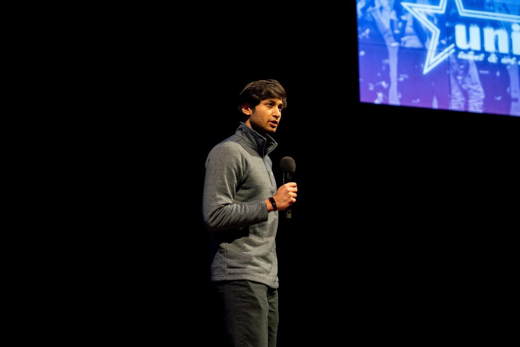 A man on stage talking into a microphone