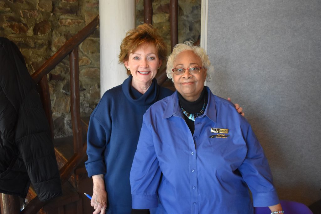 Two women pose together, smiling at the camera
