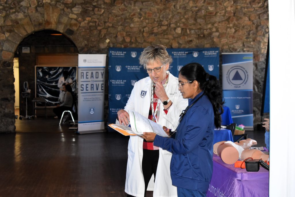 Two women look at a sheet of paper together