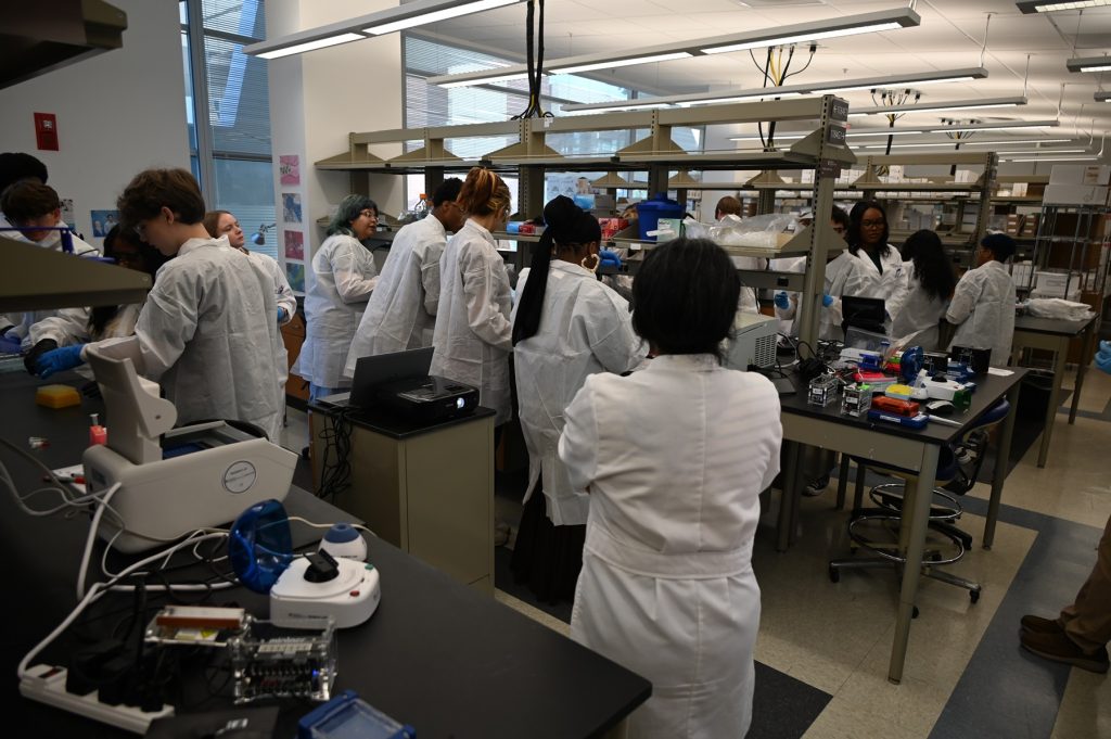 In this photo, you see students standing in a research laboratory inside the Georgia Cancer Center M. Bert Storey Research Building.