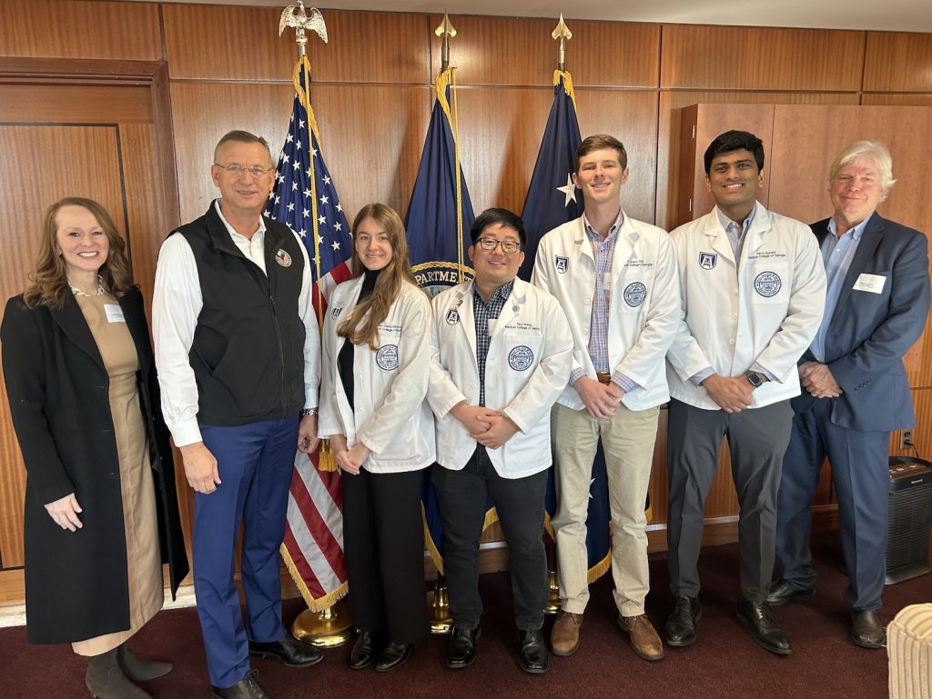 Medical students standing with Doug Collins.