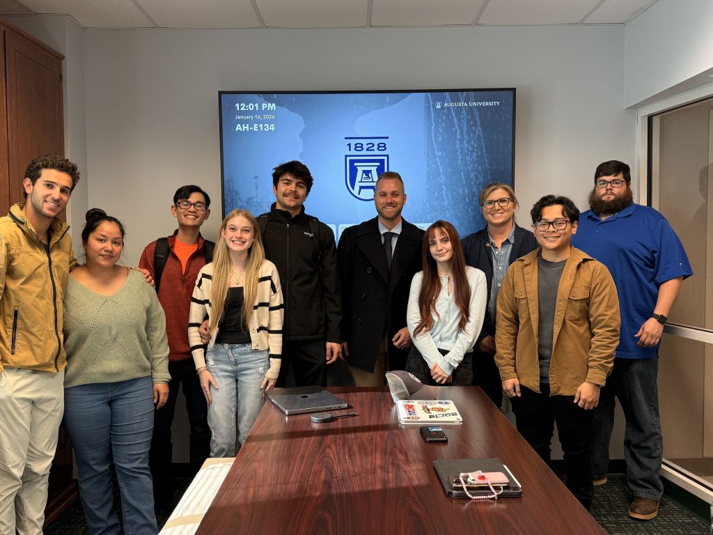 Two marketing professionals, a man and a woman, visit a college class.