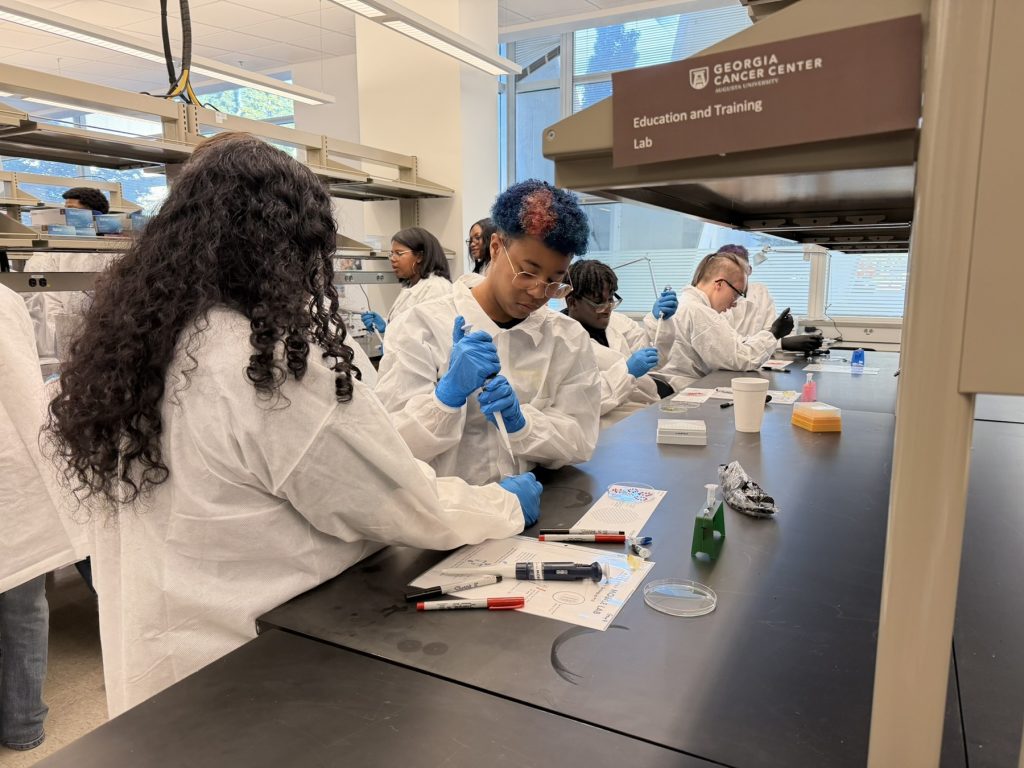 In this photo, you see students standing in a research laboratory inside the Georgia Cancer Center M. Bert Storey Research Building.