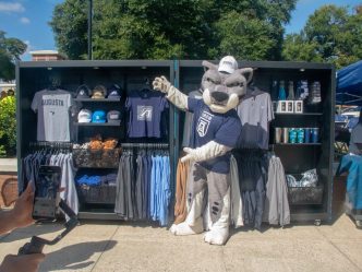 Augustus posed in front of the Merchandise Module at the Roar Store Rager
