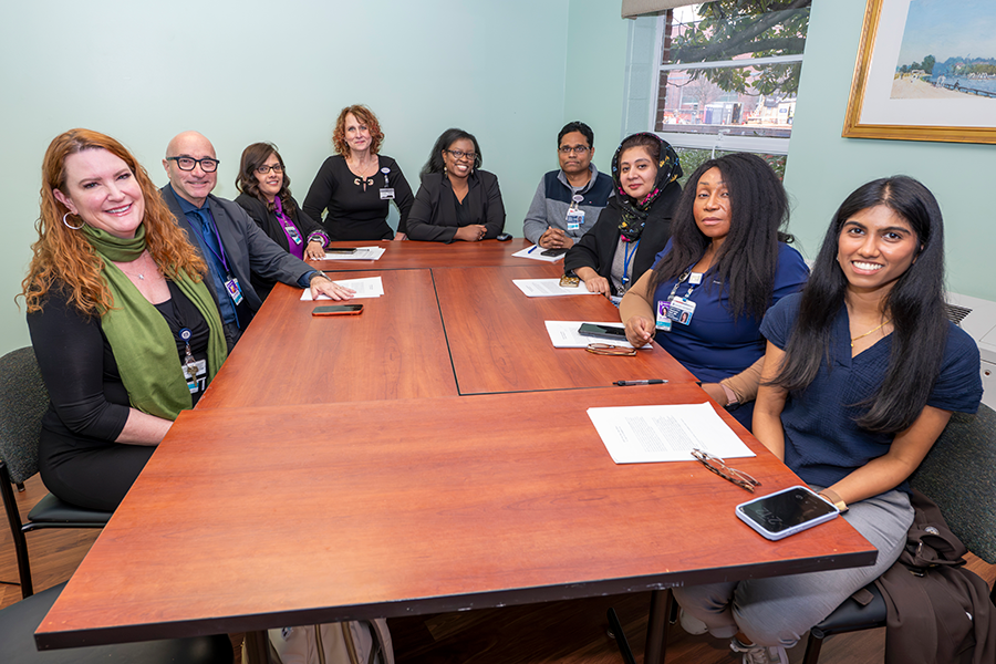 A group of doctors sit around a conference table and talk about a program they are helping with at a medical college.