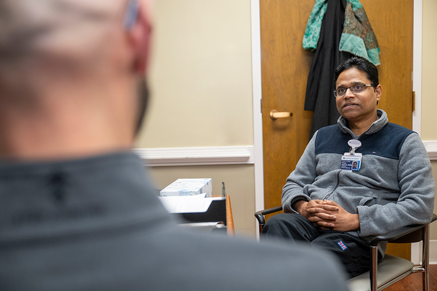 A male doctor speaks with a male patient.