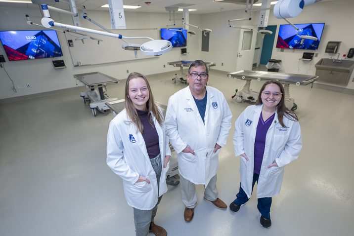 Two women and a man standing in a room