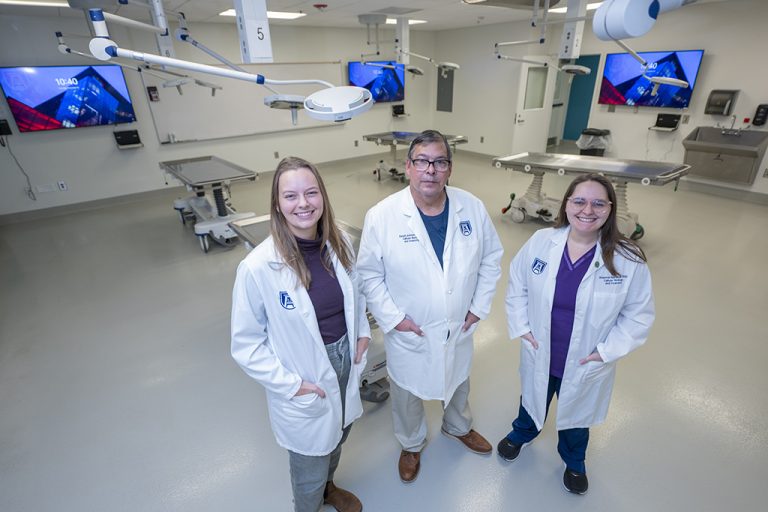 Two women and a man standing in a room