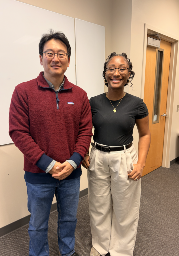 Professor poses with representative from United Way. 