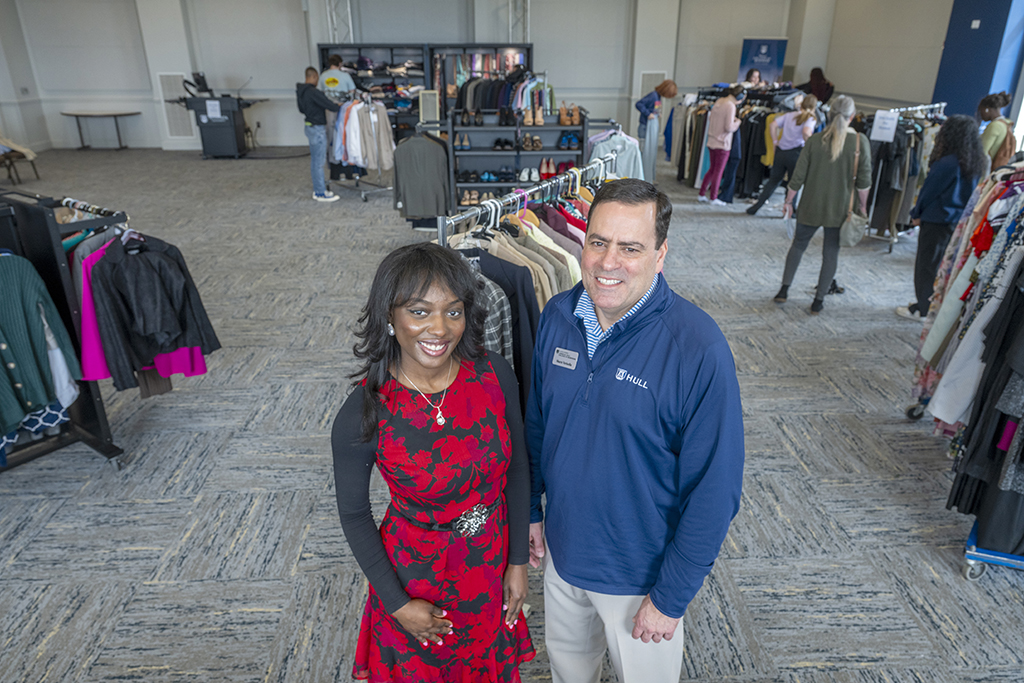 Woman and man standing in front of clothes