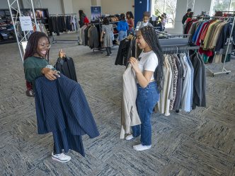 Two female students showing each other clothes