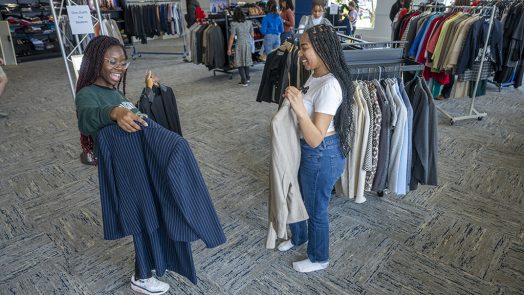 Two female students showing each other clothes