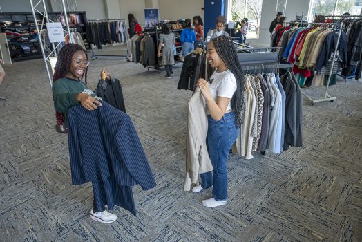 Two female students showing each other clothes