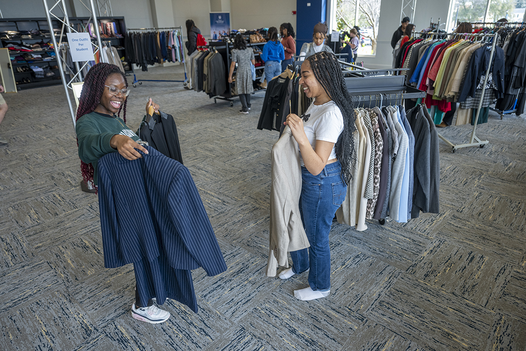 Two female students showing each other clothes