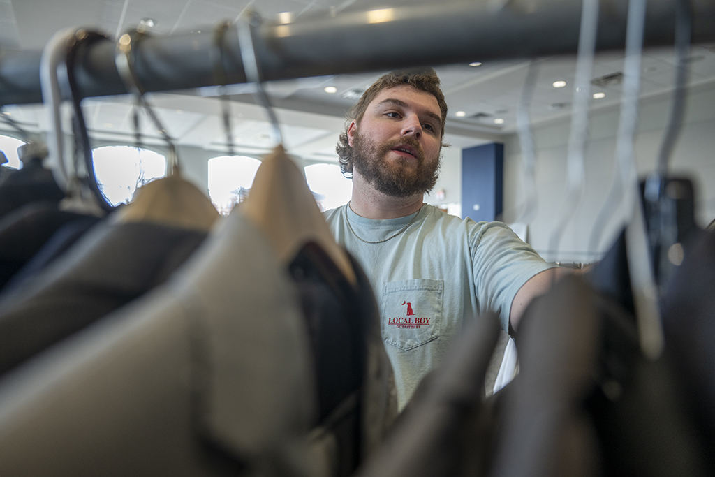 A man looking through racks of clothes