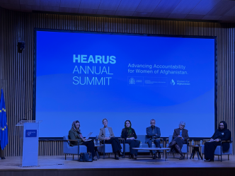 A panel of speakers and academics at a summit.
