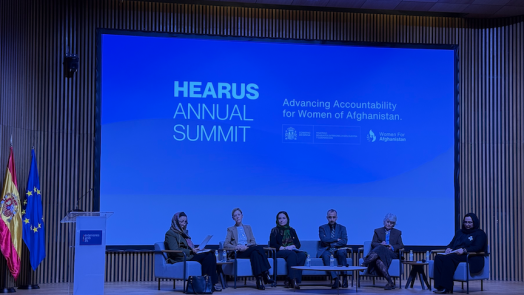 A panel of speakers and academics at a summit.