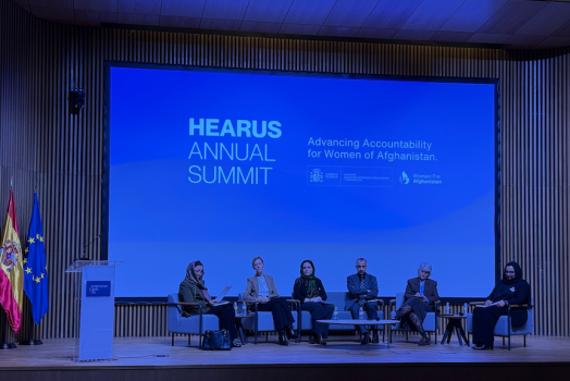 A panel of speakers and academics at a summit.