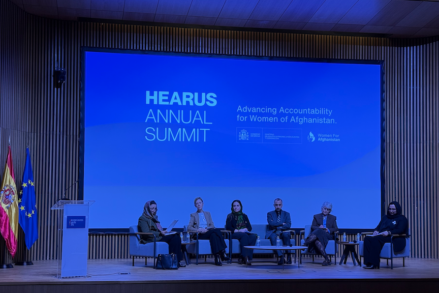 A panel of speakers and academics at a summit.