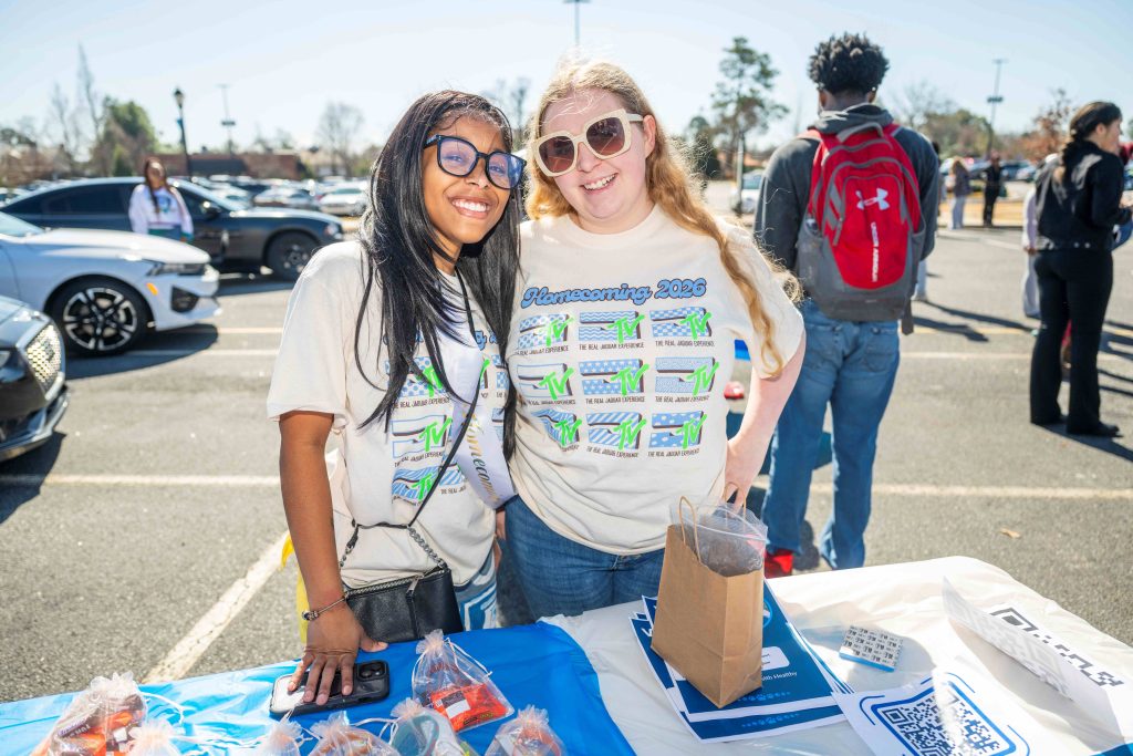 Two women in matching T-shirts smile for a photo.