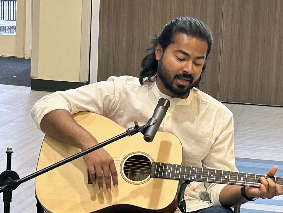 A man singing and playing a guitar