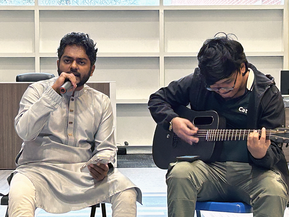 Two men singing and playing a guitar