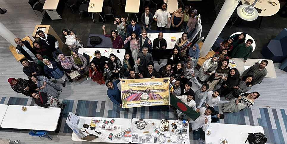 Men and women holding a sign and smiling