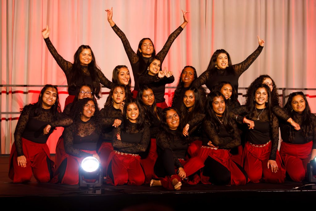 Several women on a stage pose for a photo.