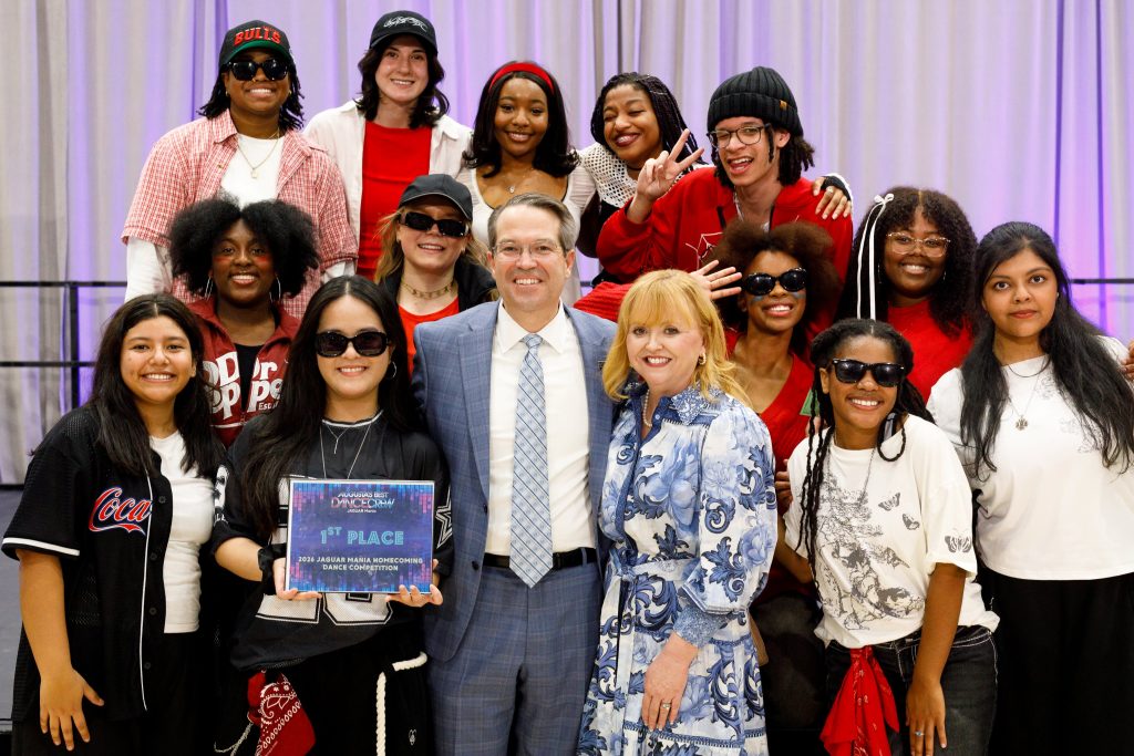 A group of men and women pose for a photo.