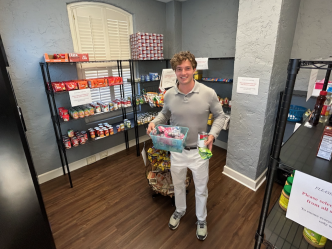 a young man standing in a food pantry holding items