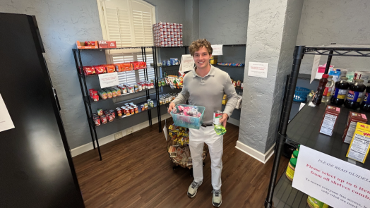 a young man standing in a food pantry holding items