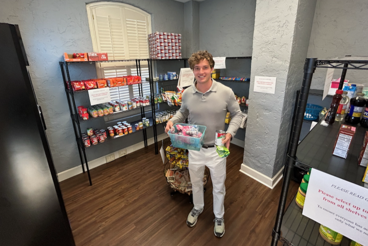 a young man standing in a food pantry holding items