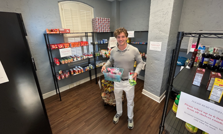a young man standing in a food pantry holding items