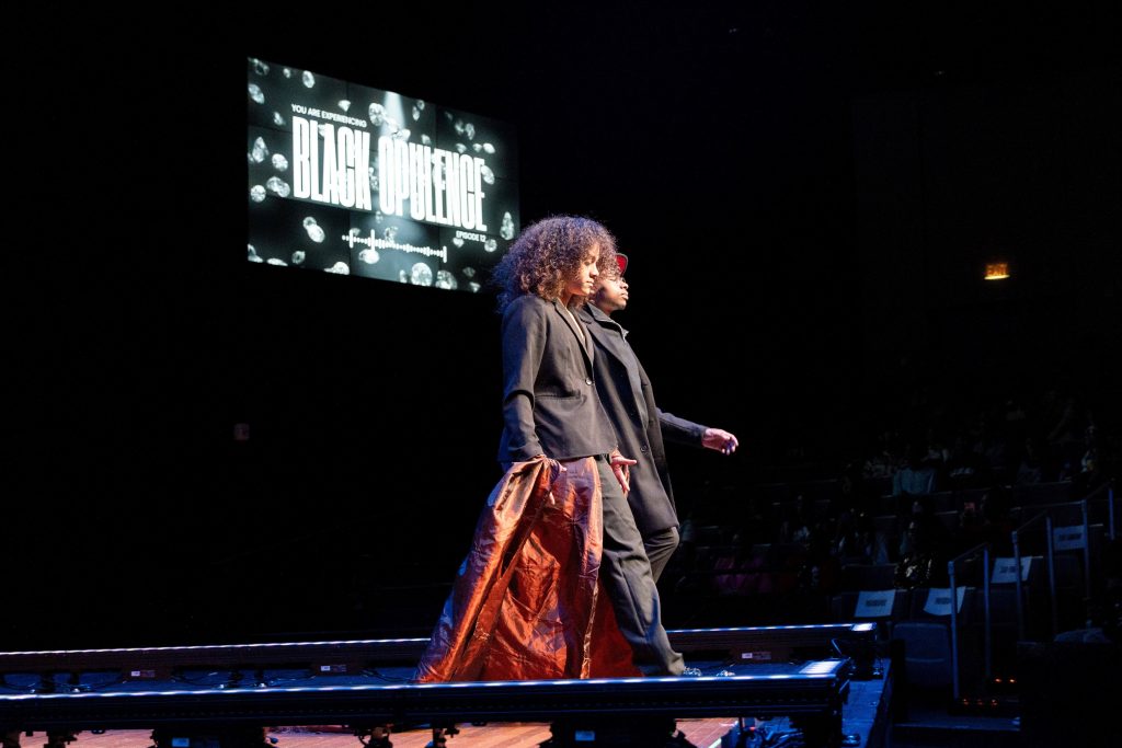Two men walk down a stage.