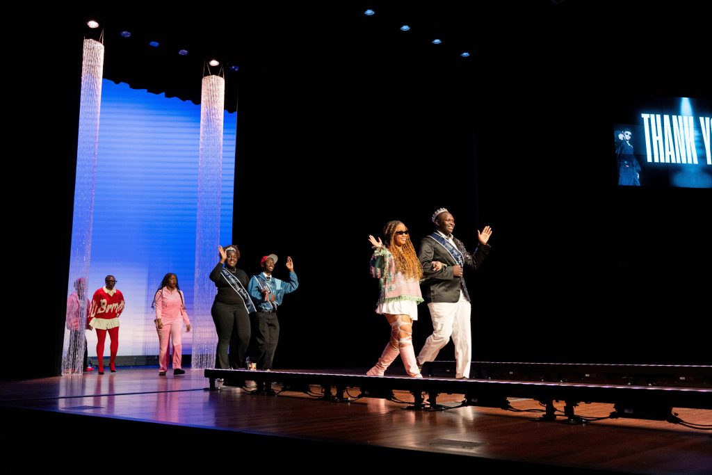 Pairs of men and women walking down a stage.