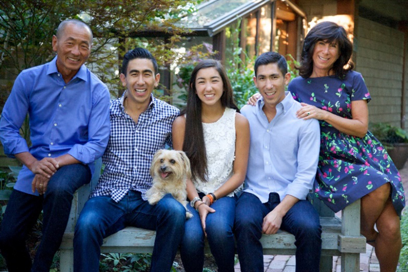 a family of five with their dog on a bench together