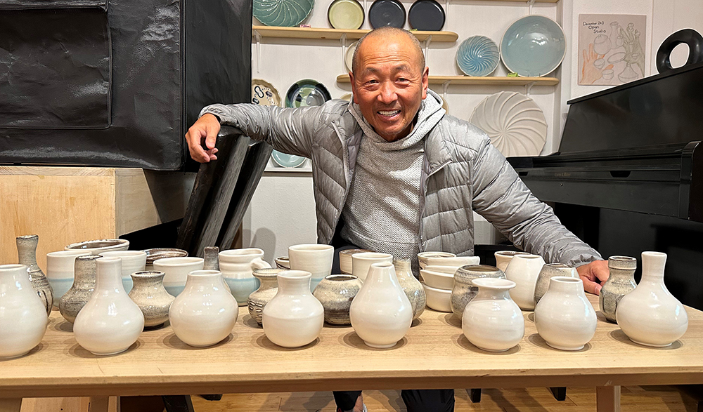man with table of pottery
