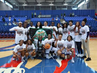 Women holding a banner and trophy posing for a team photo