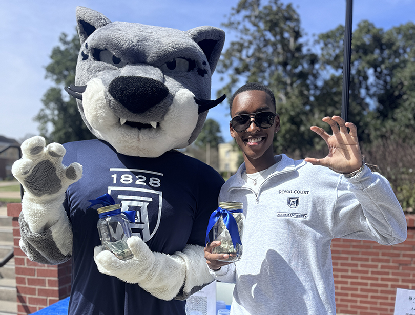 AU Jaguar mascot and student on campus