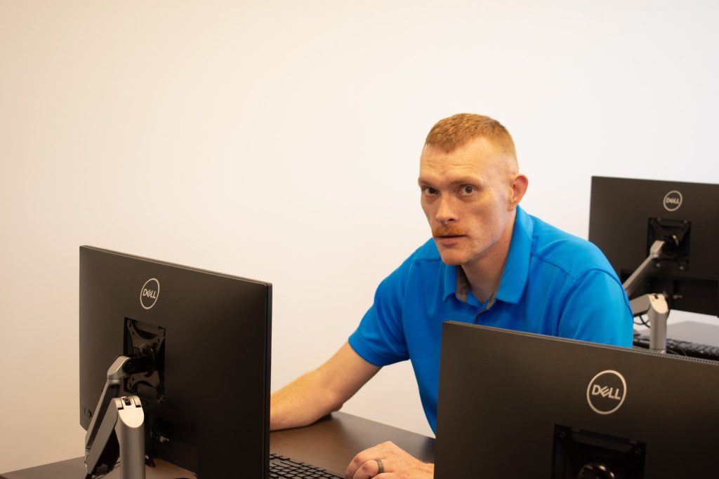 Student sitting at computer looking up.