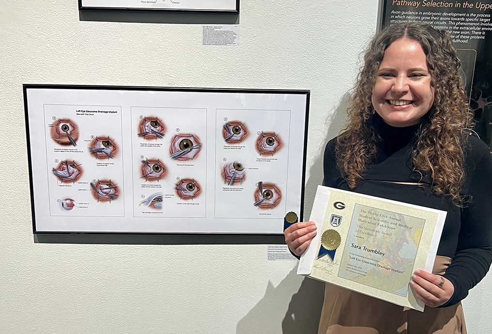 Woman holding a certificate in front of her display
