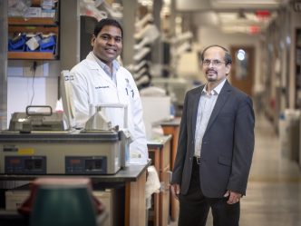 Two men standing in a research lab inside the Georgia Cancer Center's M. Bert Storey Research Building.